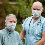 Healthcare worker supporting an older woman